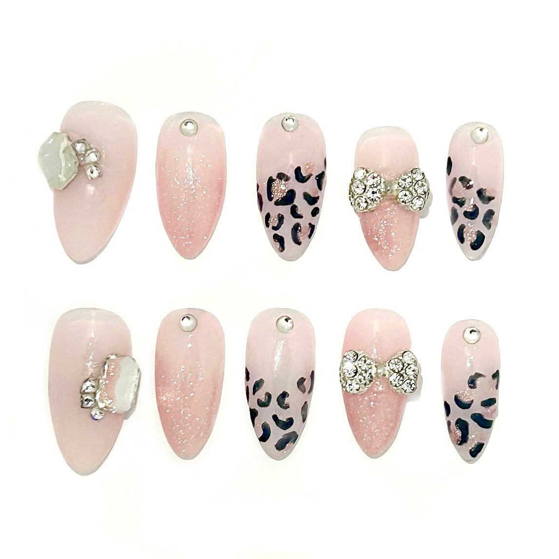 Set of pink and leopard print with decorative elements of rhinestones and a rhinestone bow charm on the ring finger. This nail set is an almond medium. 